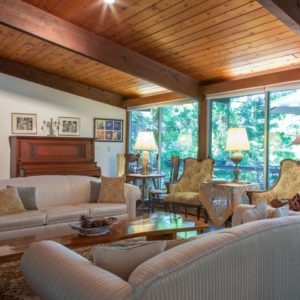 Airbnb Living Room with 2 Couches, 2 Yellow Sofas, WIndows and Wooden Ceiling