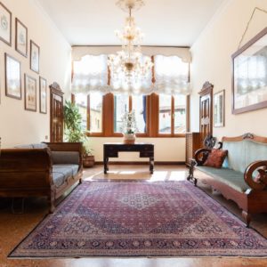Airbnb main entrance with carpet and chandelier and old venetian sofas