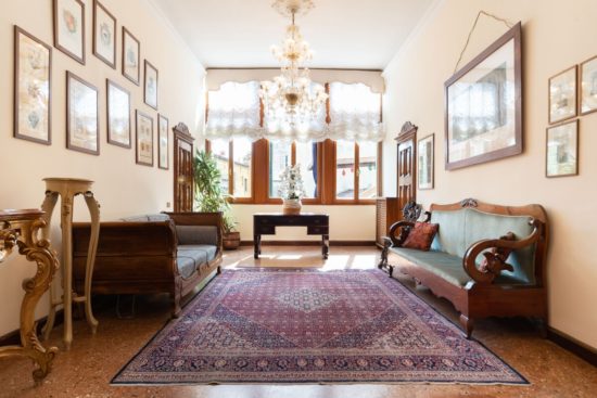 Airbnb main entrance with carpet and chandelier and old venetian sofas