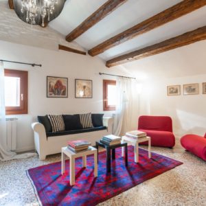 Airbnb Living Room with couch and red sofas with tables and a carpet