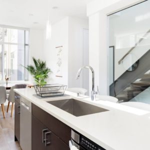 Airbnb Kitchen with White Countertop and Stairs in Background